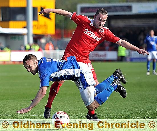 DOWN TO EARTH . . . Liam Kelly is felled by a clumsy challenge, but no penalty is awarded for Athletic.