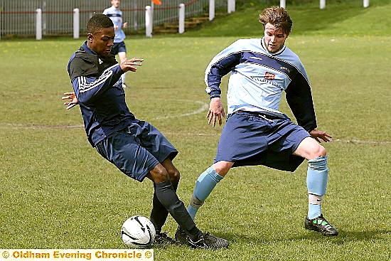 ACTION STATIONS . . . Fitton Hill’s Mark Hope (left) charges in to challenge Heyside’s Chris Ollerton in the Jack Abbott Premier Division Shield final.
