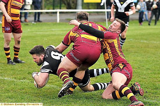 over i go: Dale Lowe dives in for Saddleworth Rangers against Wigan St Judes. 