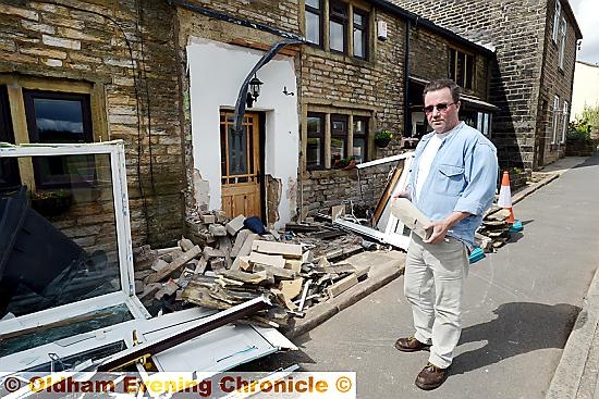 Karl Highton surveys the damage to his house