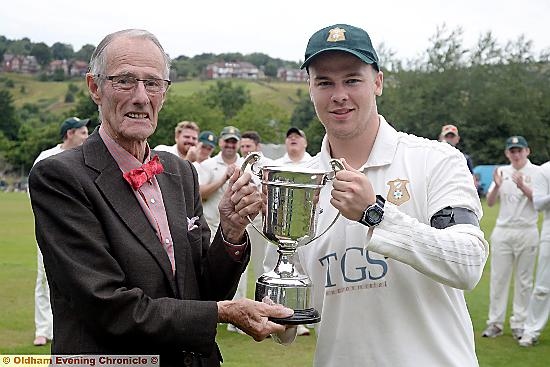 WELL DESERVED VICTORY . . . Roger Tanner presents the trophy to Saddleworth captain Brian Lord.