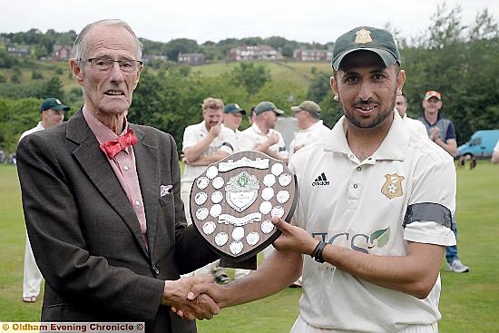 It’s yours: Mohammed Shakir receives the man-of-the-match shield from league president Roger Tanner.