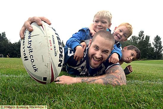 GIVE it a try: Hollinwood Junior Rugby player Ashley Dixon puts a few up and coming players through their paces, from left, Riley McCullough (5), Ollie McCullough (3) and Harry Dixon (4). 