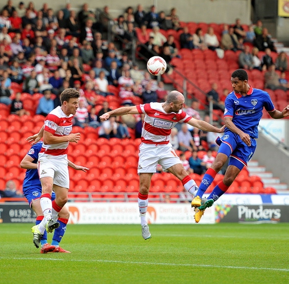 HIGH FLIER: Timothee Dieng leaps above the Doncaster defence to power a header towards goal. 