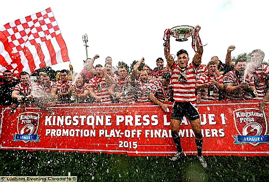 CHAMPIONS . . . Lewis Palfrey holds aloft the League One Championship Rose Bowl and Oldham Rugby players celebrate after their promotion play-off success against Keighley Cougars