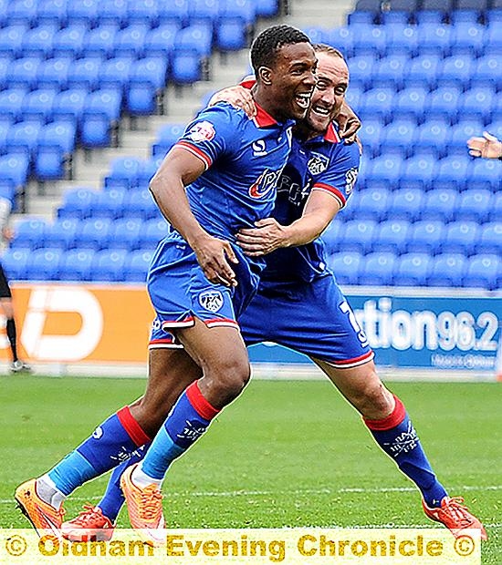 ALL-SQUARE . . . Dominic Poleon gets a hug from Lee Croft after equalising for Oldham on Saturday. 