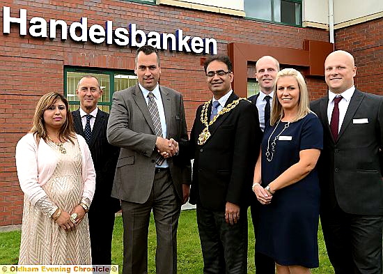 SHAKE on it (from left): Mayoress, Councillor Yasmin Toor; Handelsbanken area manager, Simon Raine; Oldham branch manager, Scott Parkinson; Mayor of Oldham, Councillor Ateeque Ur-Rehman; and Andrew Harrison, Nicola Mitchell and Chris Ainsworth, all from Handelsbanken in Oldham