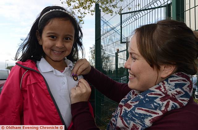BADGE of honour . . . 

Madihah Miah with one of the badges being pinned on by the school's eco co-ordinator Charlotte Squibbs