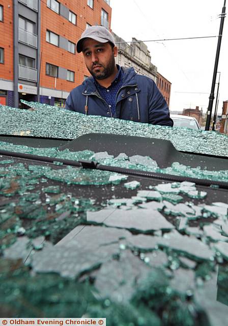 Taxi drivers complain about yobs throwing bricks at their cars in Moorside. PIC shows driver of affected car Khizar Islam. Looking through smashed rear window.
