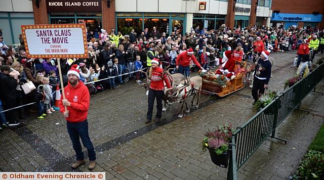 CROWDS gather to greet Santa's arrival in the town centre
