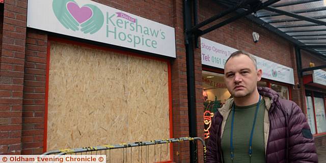 Darren Hunt, manager of Dr Kershaw's Hospice charity shop in Albion Street, Oldham shows where a raider smashed the front window during a break-in
