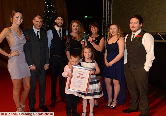 GUEST APPEARANCE . . . Special Achievement Award winners Chadderton Wellbeing Centre staff who help road accident victim Oliver Smethurst (5), pictured in front with his sister Megan(6). Mum Shirley Davey is holding the trophy.
