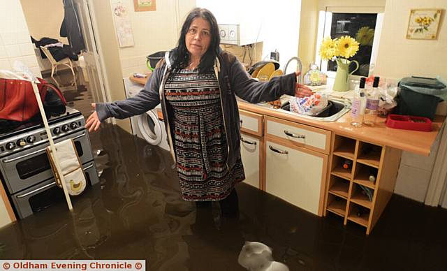KITCHEN misery . . . Lisa Watson in her flooded home in Chew Valley Road 