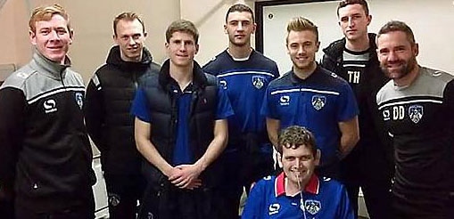 NUMBER one fan . . . Nathan (front, seated) with Latics players and staff who visited him in hospital last month