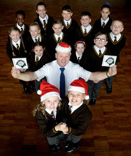 CHART success . . . front, from left, Amelia Nolan (8), school technician manager Nigel Mulligan who wrote the song and Jessica Smith (9) with fellow pupils who sang on the recording
