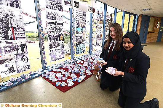 pupils Grace Lowe and Tahmina Ali with paper shoes which formed part of a display at Holocaust memorial display at Radclyffe School