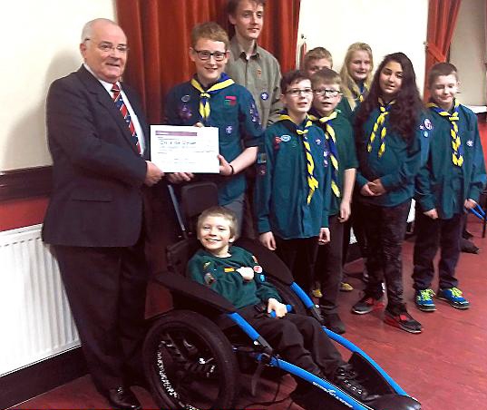 READY to go camping... Dylan Bradley in his new wheelchair, with Ian Whitehead (left, Charity Steward for Salford District Freemasons) presenting patrol leader George Symons with a cheque for £1,500