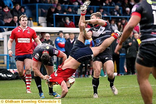 WELCOME TO THE CHAMPIONSHIP . . . Oldham’s Danny Langtree is upended by a London Broncos tackle. 