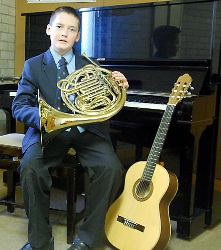 MUSICAL youth . . . James Fitzsimons plays guitar, piano and French horn — and he sings as well
