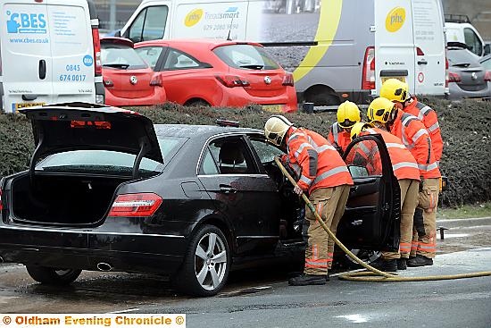 FIREFIGHTERS work on the damaged Mercedes