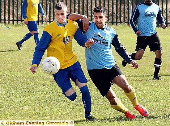 Muzzar Ali of Coppice United, goes shoulder to shoulder with his Rifle FC opposite number