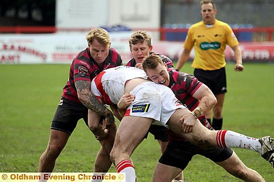 STOP THERE . . . Oldham trio Danny Langtree (left), Gareth Owen and Will Hope halt a Hull KR attack in the previous round.