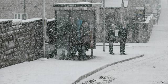 DELAYS... Snowy conditions in Saddleworth cause commuters to wait on delayed buses.