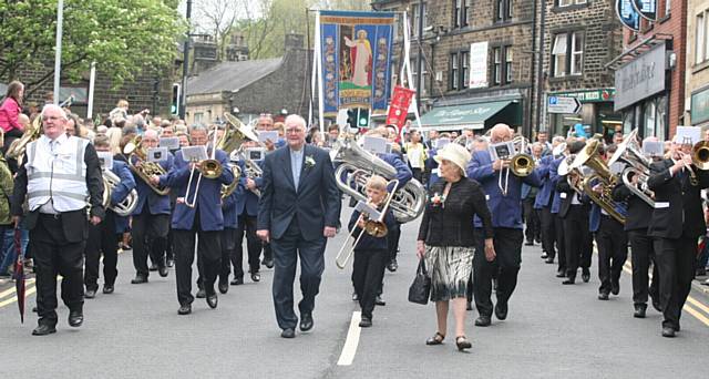 Whit Friday walks in Uppermill. At the front of the procession, L/R, Reverend, Duncan Rhodes, Dorothy Rhodes, secretary of Diggle band.
