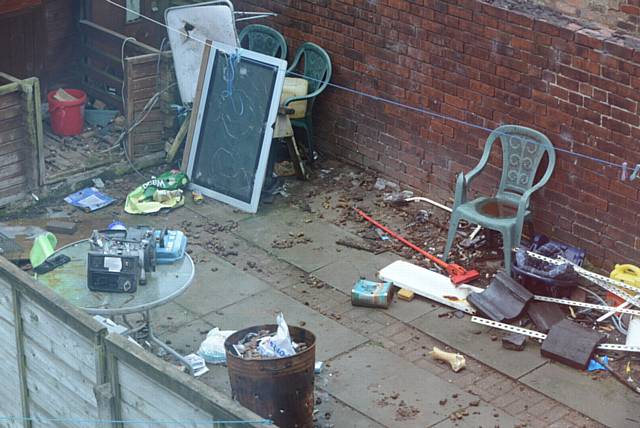 Derek Taylor complaining about the state of his neighbours' back gardens, one on the left has a discarded toilet in it while the one to the right is full of dog excrement.
