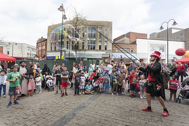 Street entertainment in Oldham town centre. The Bubble Wizard entertains the crowd.
