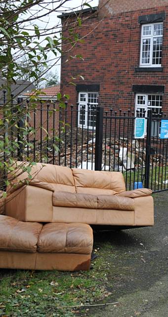 Fly tipping Clarksfield Road, Oldham right next to a fly tipping sign for maximum fine of £50,000