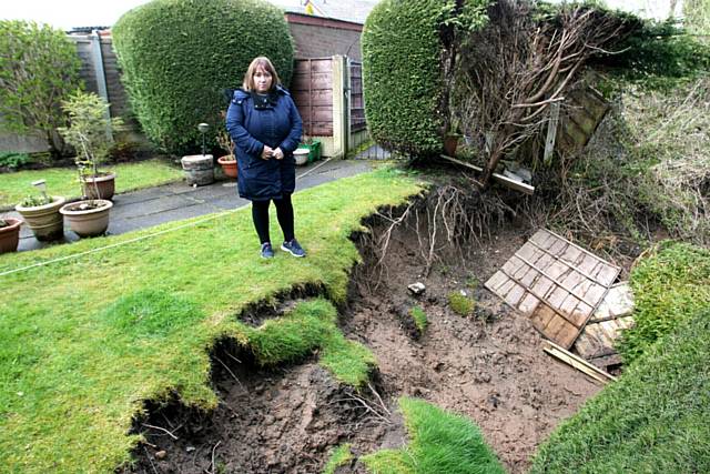 Sharon Curley in the back garden of her mother's house, part which has vanished in a land slide. 