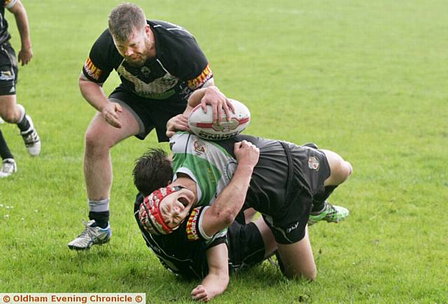 Harry Aaronson, of Saddleworth Rangers, feels the force of a Stanningley tackle.
