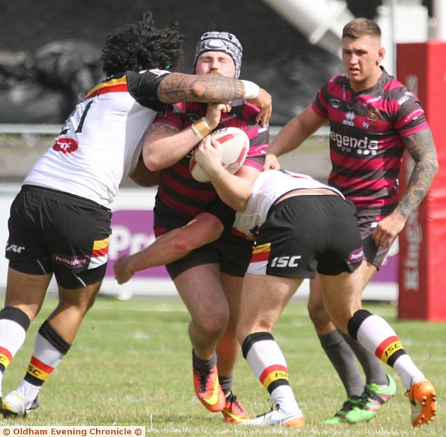 CRUNCH TIME . . . Oldham's Michael Ward (left) is halted in his tracks by the Bulls.