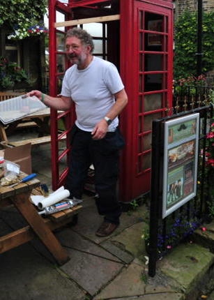 PAUL CLEGG reglazing a phone box - the defib's new home