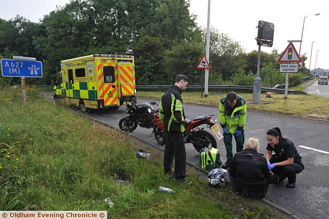 Motorcycle involved in RTA at Elk Mill roundabout, Oldham. Paramedics attend to injured rider.