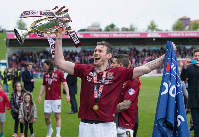 FORMER Athletic star Zander Diamond lifts the League Two title trophy