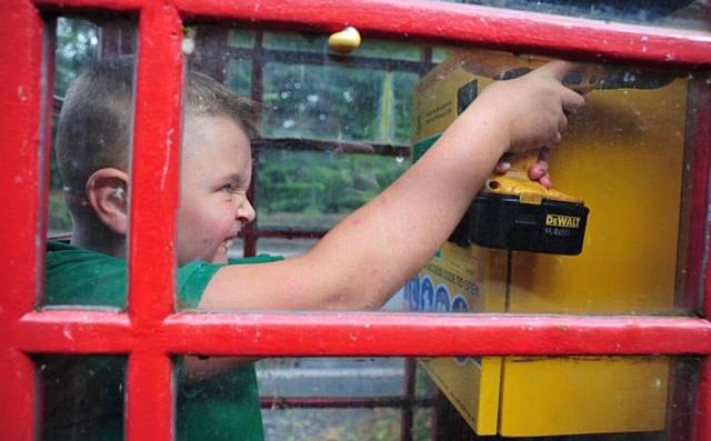TEDDY Royle (10) installs the defibrillator in the former phone box in Ladcastle Road