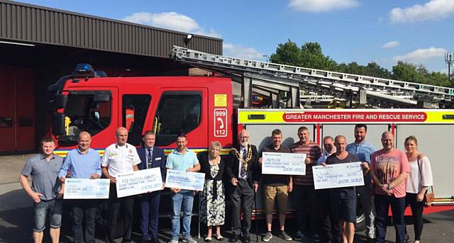FUNDRAISING firefighters . . . the team hand out cheques to their chosen charities
