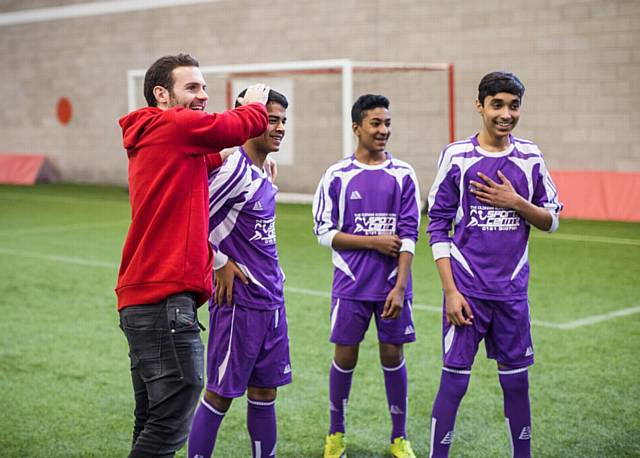 Manchester United player Juan Mata with year 9 Oldham Academy North pupils (from left) Ali Muhammed, Mamnun Hussain, and Shuhab Miah at an event to celebrate the Manchester United Foundation.
