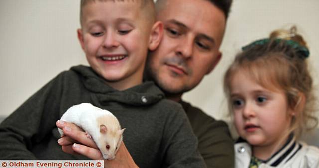Fang the hamster back in the hands of his family, Zac, Pixie-Belle and Andy Sykes