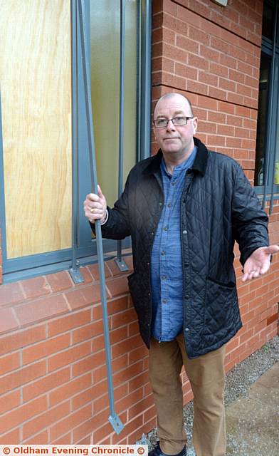REV. Arthur Janes holding a metal bar which was pulled away from the window before it was smashed