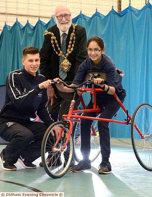WHEEL fun . . . Laibah Zaid, from Hathershaw College, on the race-running bike with sports development apprentice Adam Morris and the Mayor of Oldham Councillor Derek Heffernan
