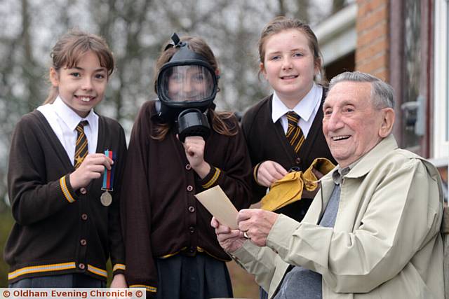 AMELIA Shoel tries out a gas mask with Lucy McGiffen, Niamh Brown and war veteran Gerry Cooper