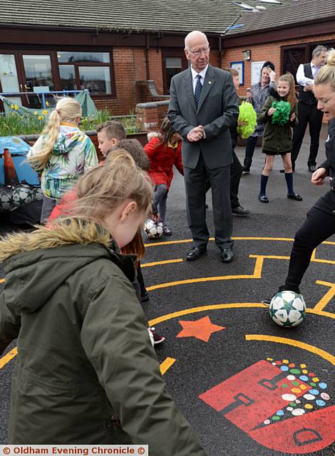 PLAY time . . . Sir Bobby Charlton watches football training in the playground at Woodlands
