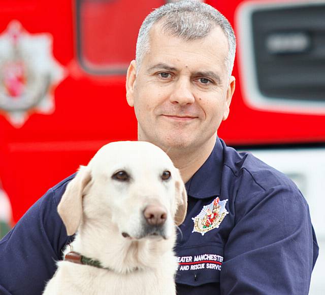 BOWING OUT . . . Lucy with dog unit manager Mike Dewar of Greater Manchester Fire & Rescue Service