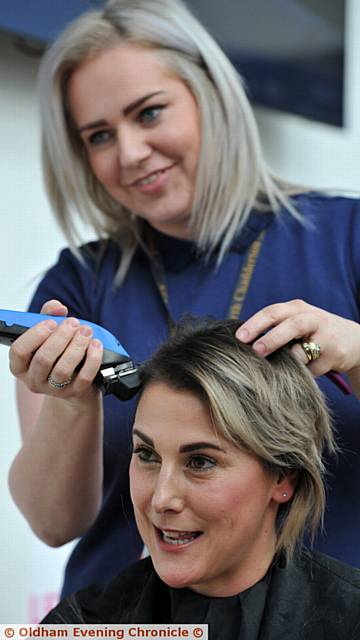 CLOSE SHAVE: Teaching assistant Amy Williams gets to work on Sarah Mossop's locks