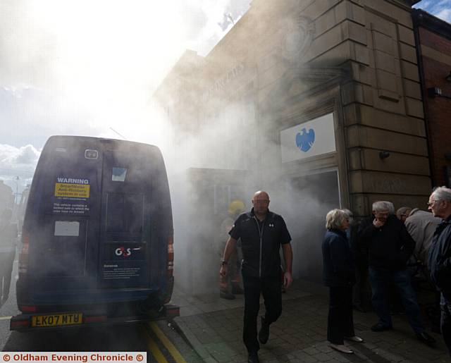 SMOKE signals . . . the moment a security van is targeted outside Barclays in Shaw