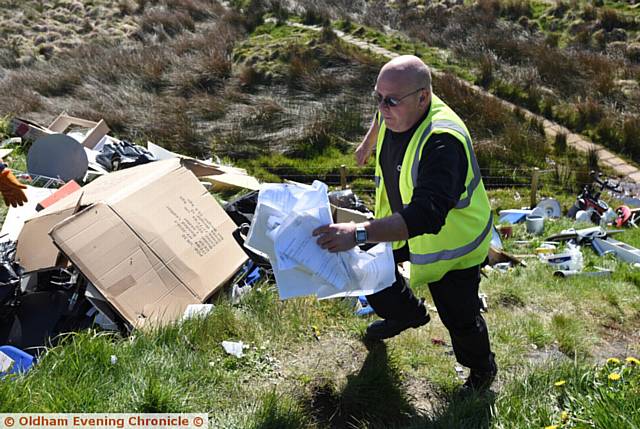 Fly tipping on Huddersfield Road near Denshaw. Copies of personal documents ie passport, driving licence etc found in rubbish. PIC shows Kirklees Council taking away documents.
