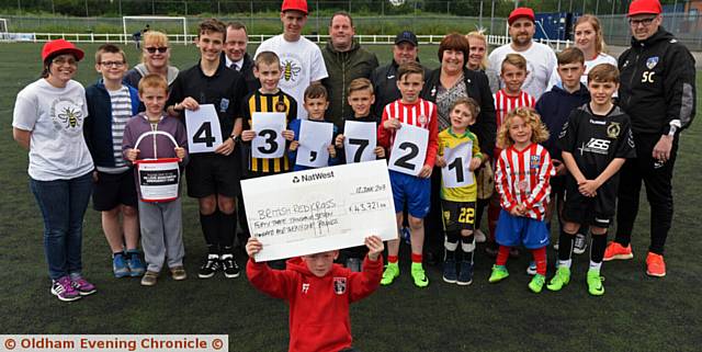 FUNDRAISERS . . . Six-year-old Freddie Farnell, from Springhead FC, holds the cheque aloft with other volunteers, organisers and participants from the 24-hour football marathon
